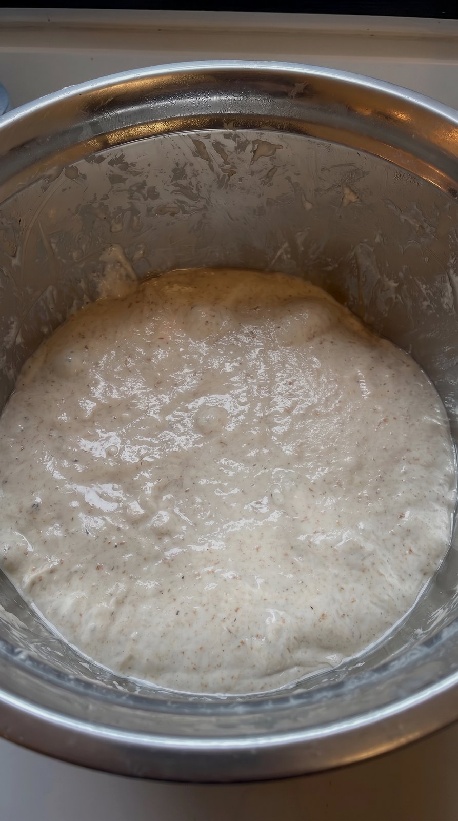 Failed watery dough with undissolved stiff starter lumps visible in the mixing bowl