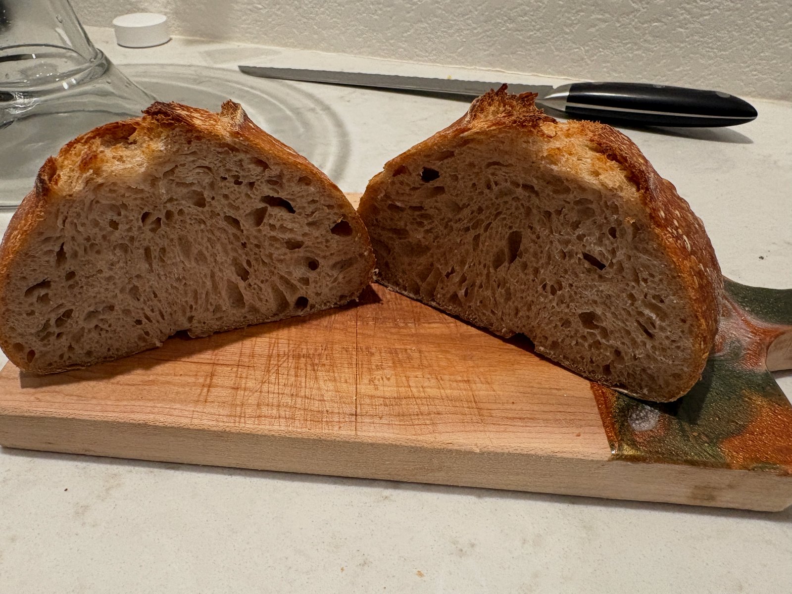 Sliced sourdough boule with an even open crumb and a broad low dome